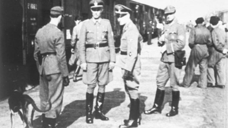 Albert Gemmeker (derde van links) in 1943, op de achtergrond een veewagon met Auschwitz als bestemming. (Foto: Beeldbank WO2 – NIOD)